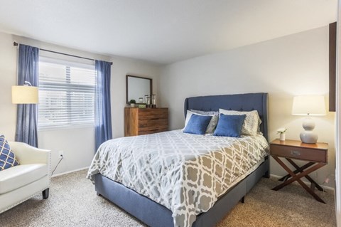 A bedroom with a large bed and a white couch.
