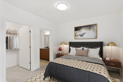 A bedroom with a large bed and a painting on the wall.