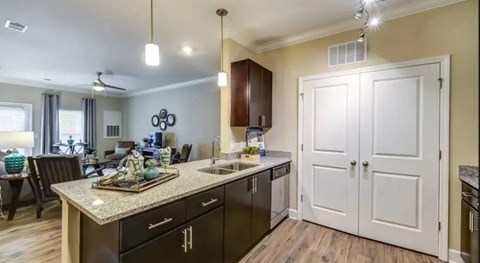 A kitchen with a white door and a counter with a bowl of fruit on it.