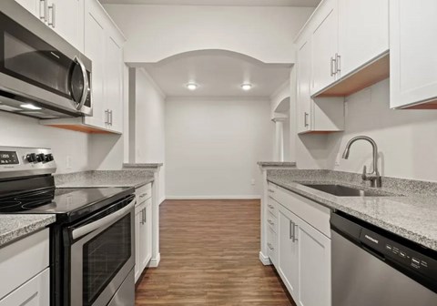 A kitchen with white cabinets and a black stove top oven.