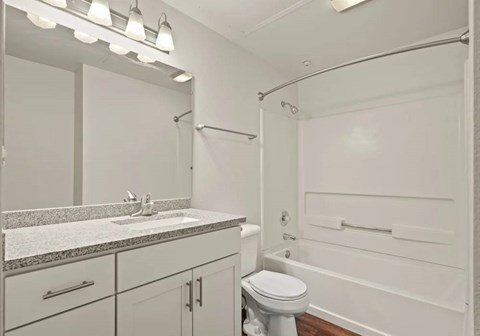 A white bathroom with a sink, toilet, and bathtub.