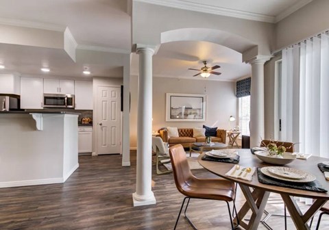A modern dining room with a wooden table set for two.