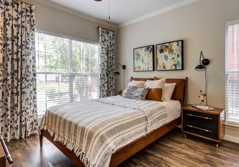 A bedroom with a large bed and a wooden floor.