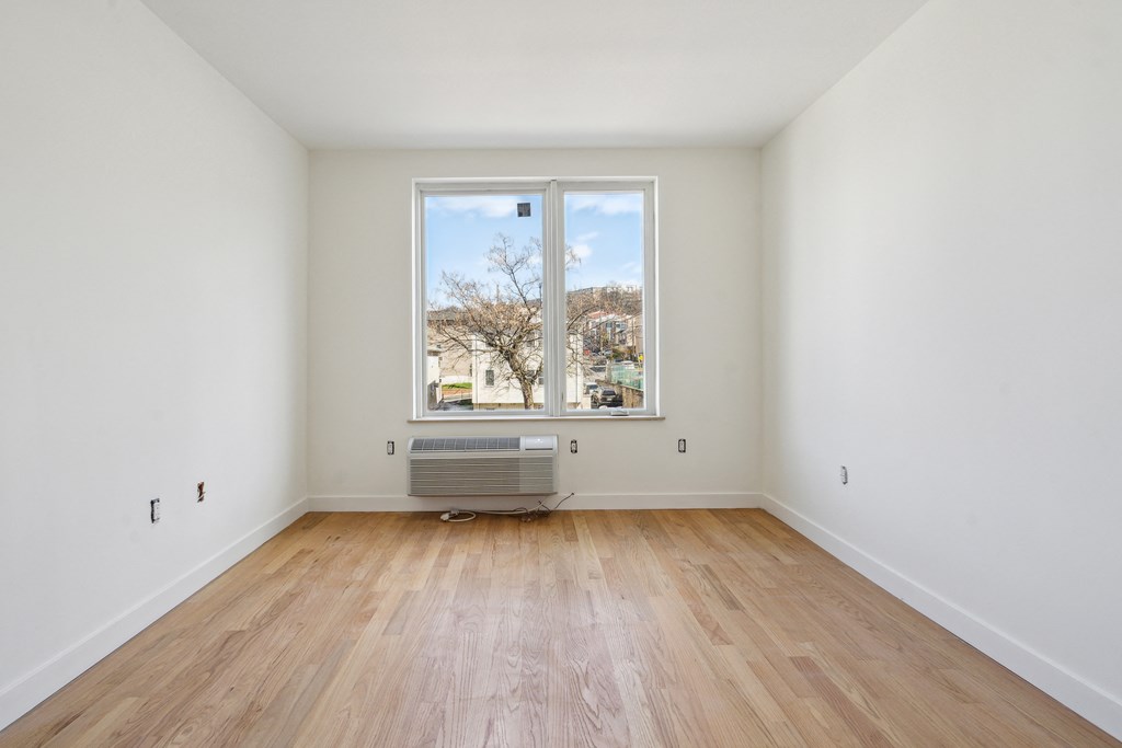 a living room with a large window and wooden floors