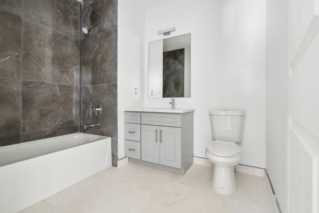 a bathroom with two toilets and a sink and a mirror