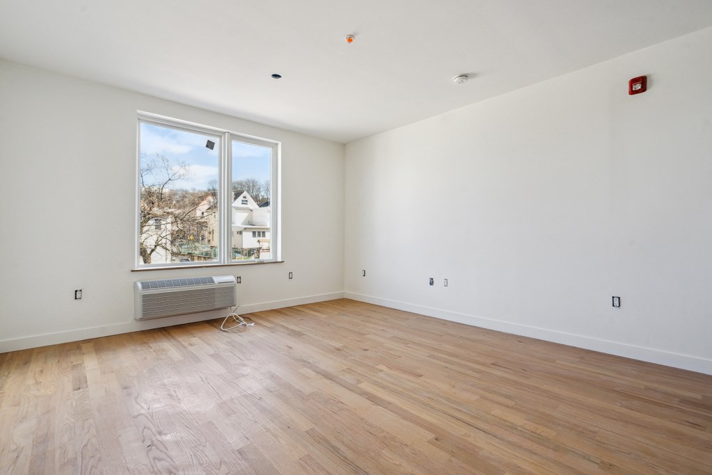 a living room with wood floors and a large window