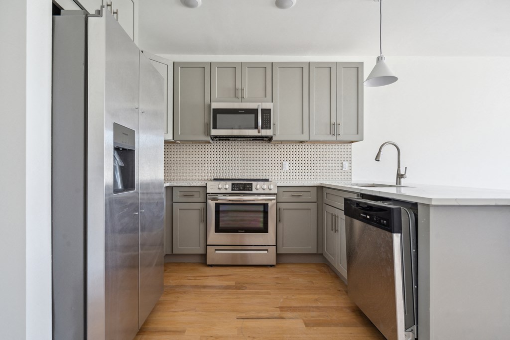 a kitchen with white cabinets and stainless steel appliances