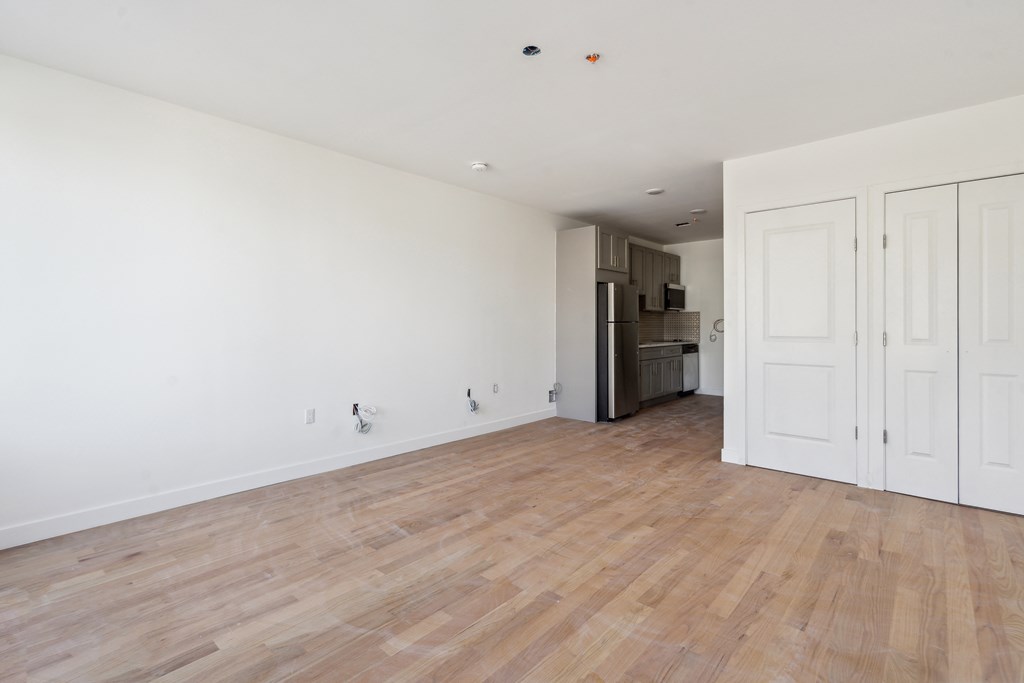 an empty living room with white walls and wood floors