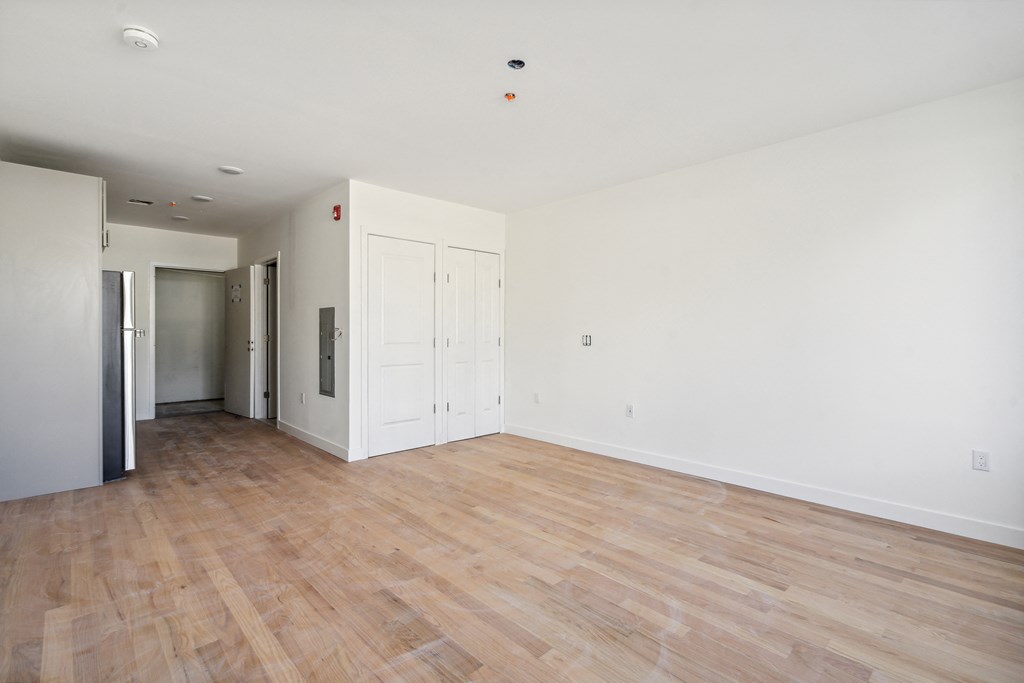 an empty living room with white walls and wood floors