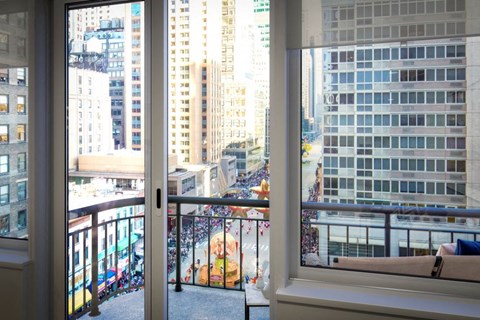 a room with a balcony and a view of the city