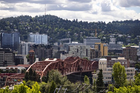 a bridge over a city with mountains in the background at Analog PDX Apartments, Portland, OR