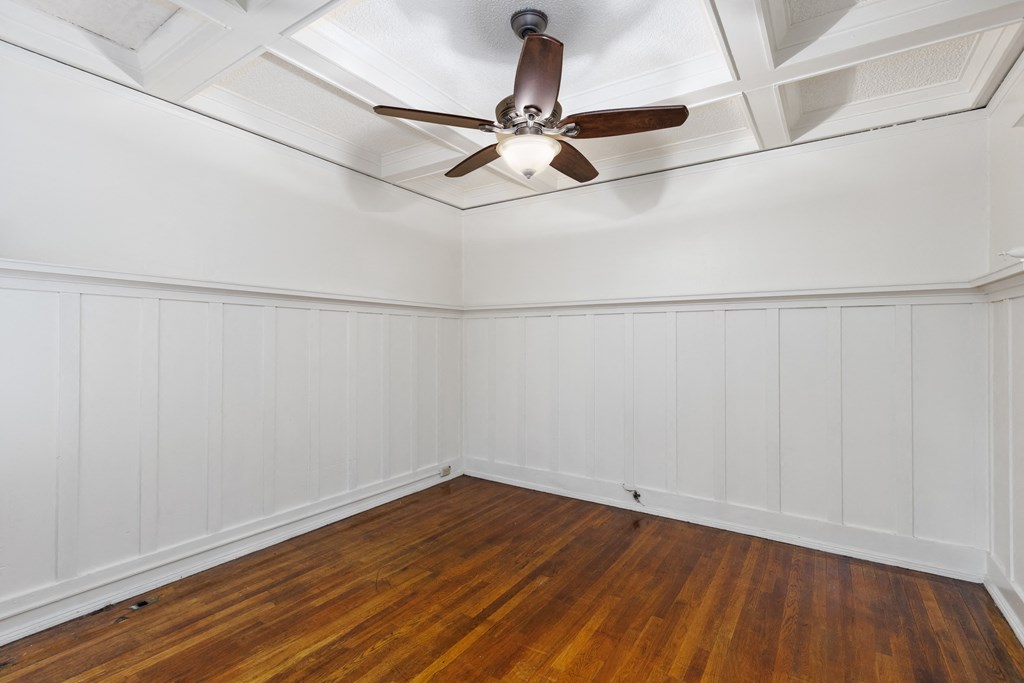 an empty room with a ceiling fan and hardwood floors