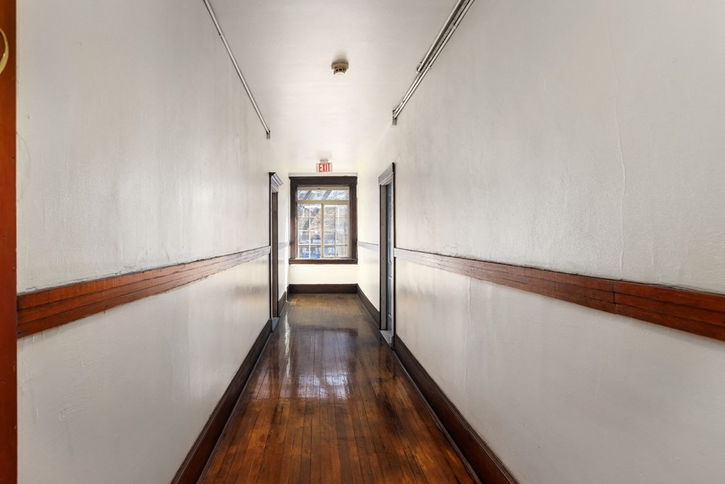 a hallway with wood floors and white walls