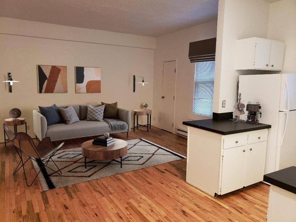 an open living room and kitchen with a wood floor