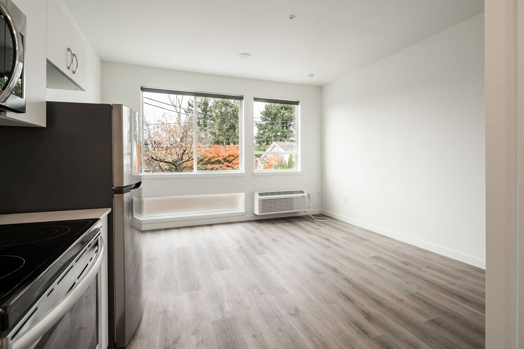 an empty kitchen and living room with a large window
