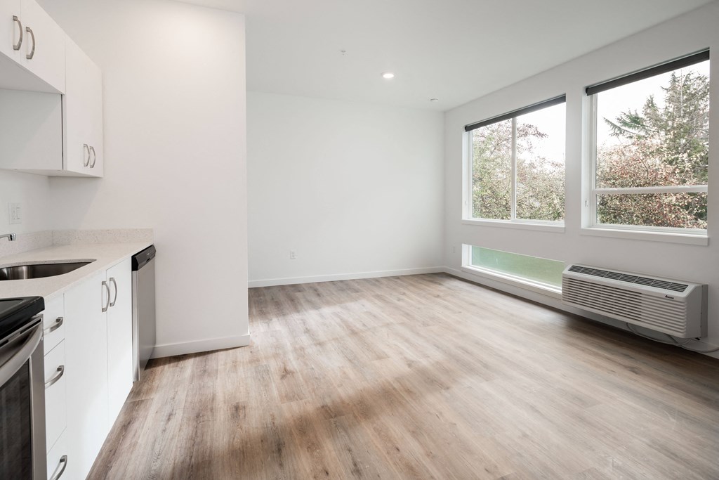 an empty kitchen and living room with a large window