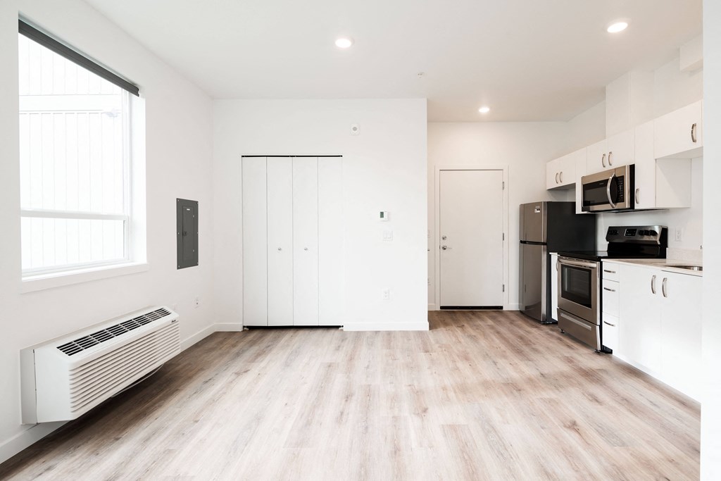 an empty living room with white walls and wood flooring