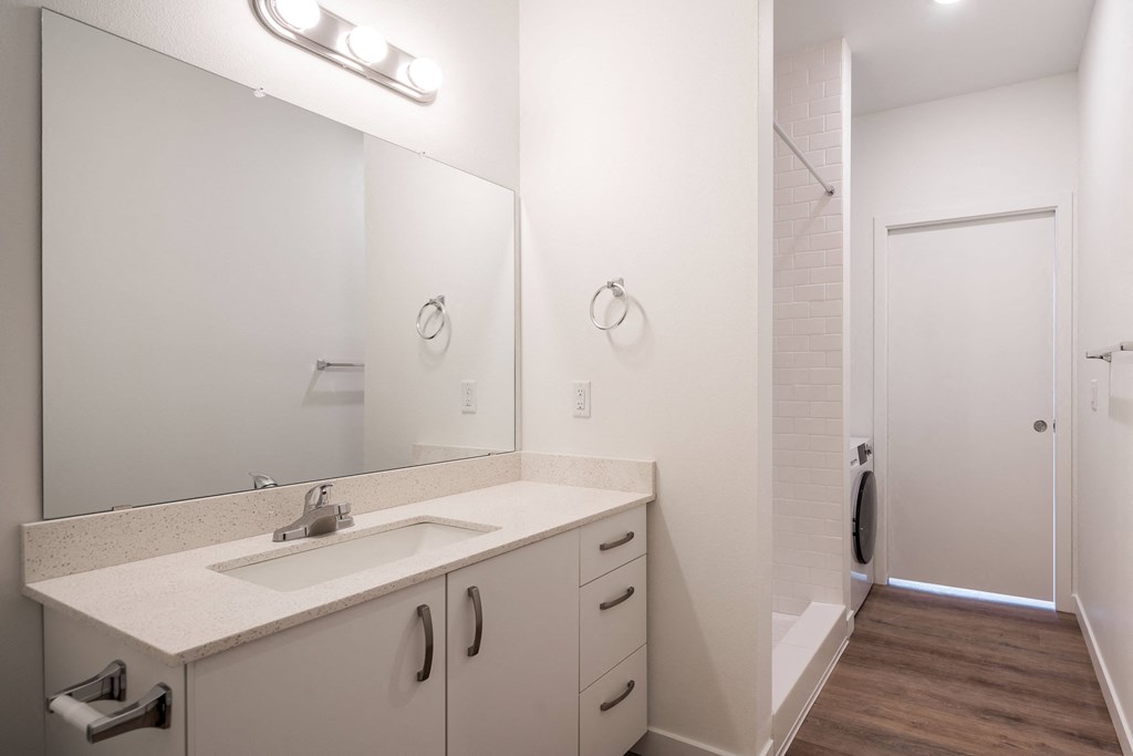 a white bathroom with a sink and a mirror