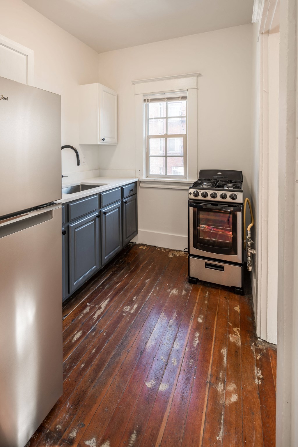 a kitchen with blue cabinets and a stove and a window