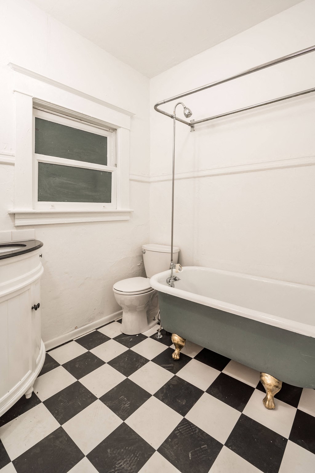 a bathroom with a black and white checkered floor and a bath tub
