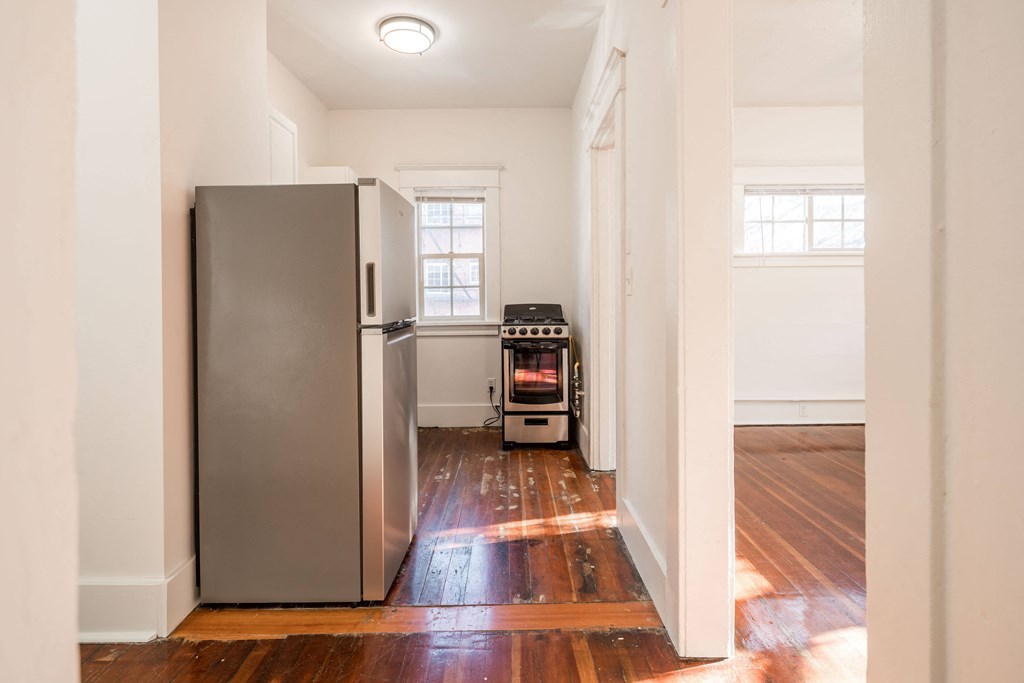 an empty room with a refrigerator and a stove in it
