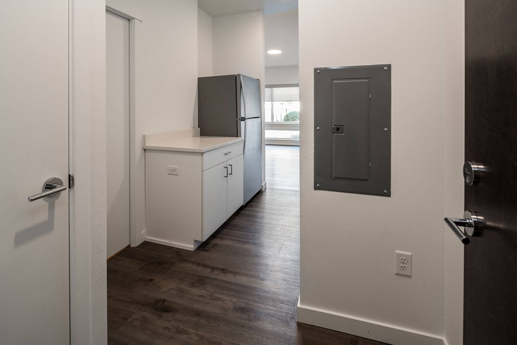 a kitchen with white cabinets and a refrigerator and a door