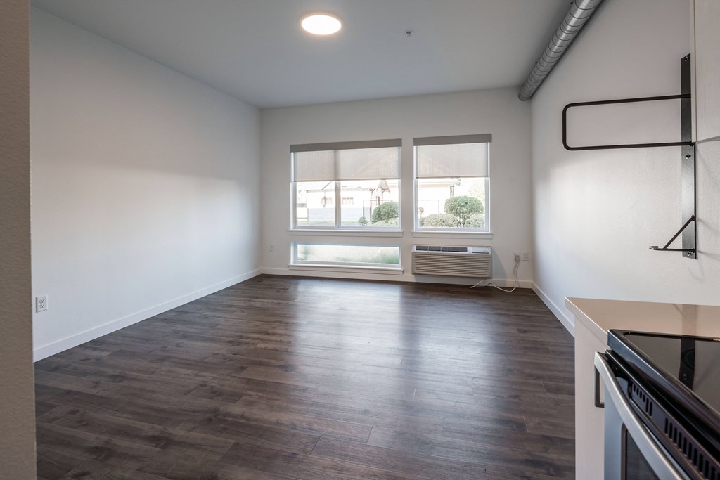an empty kitchen and living room with a large window