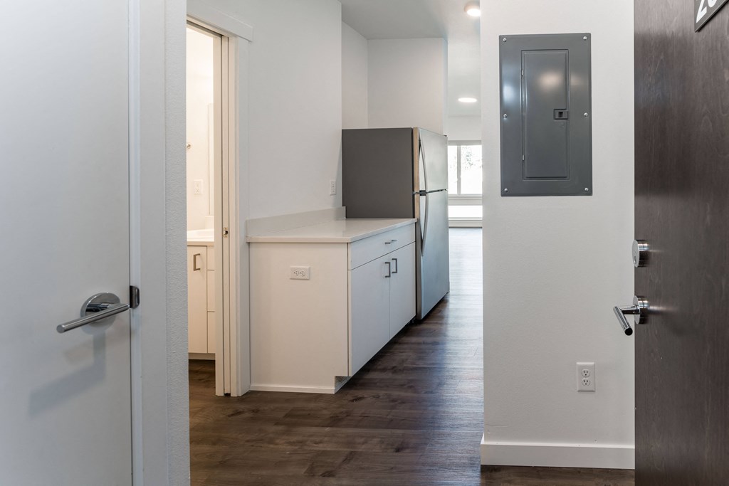 a kitchen with white cabinets and a refrigerator and a door