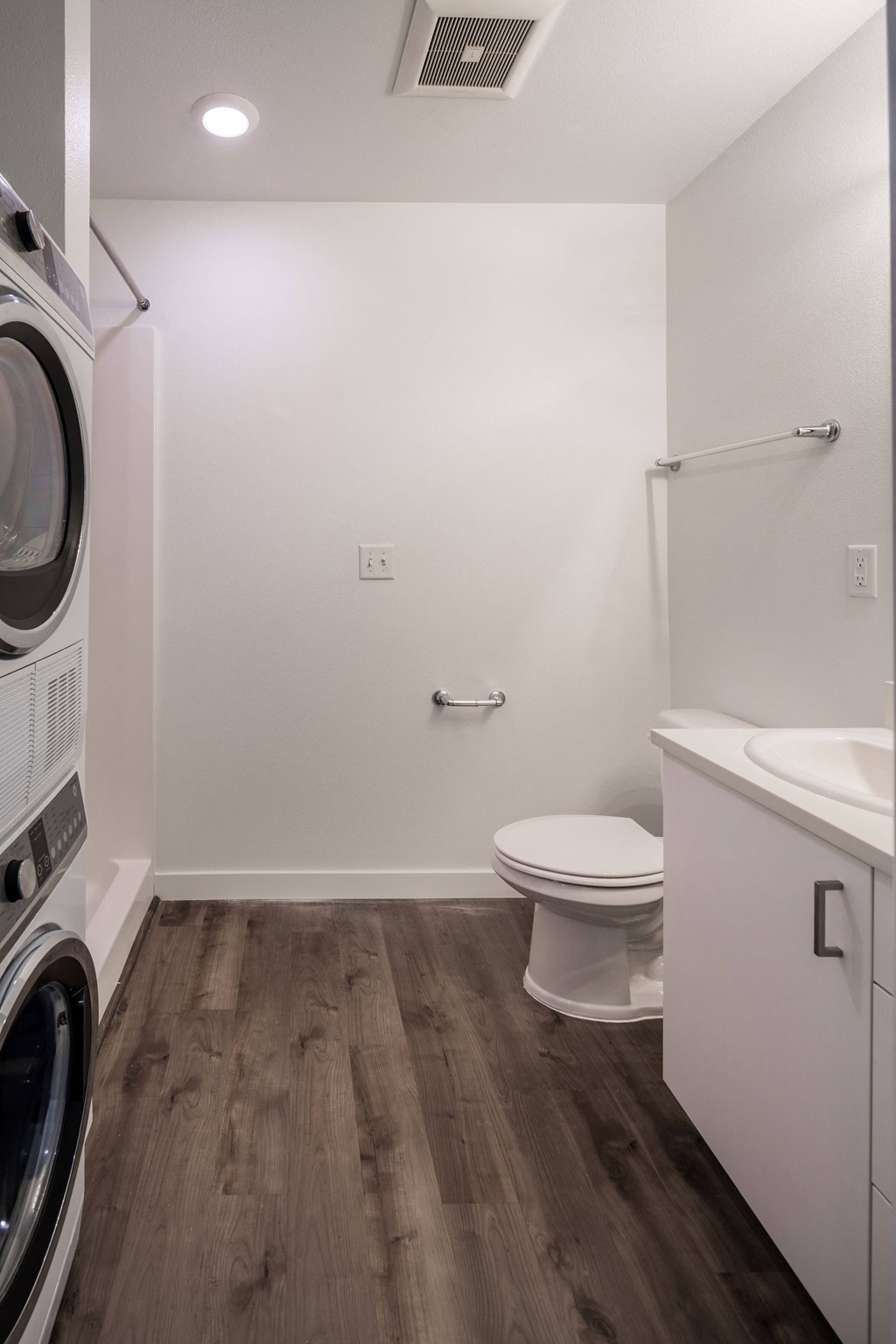 a small bathroom with a toilet and a washer and dryer in it