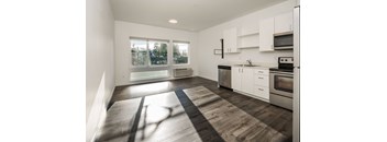 a kitchen with white cabinets and a large window