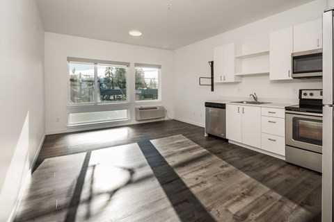 a kitchen with white cabinets and a large window