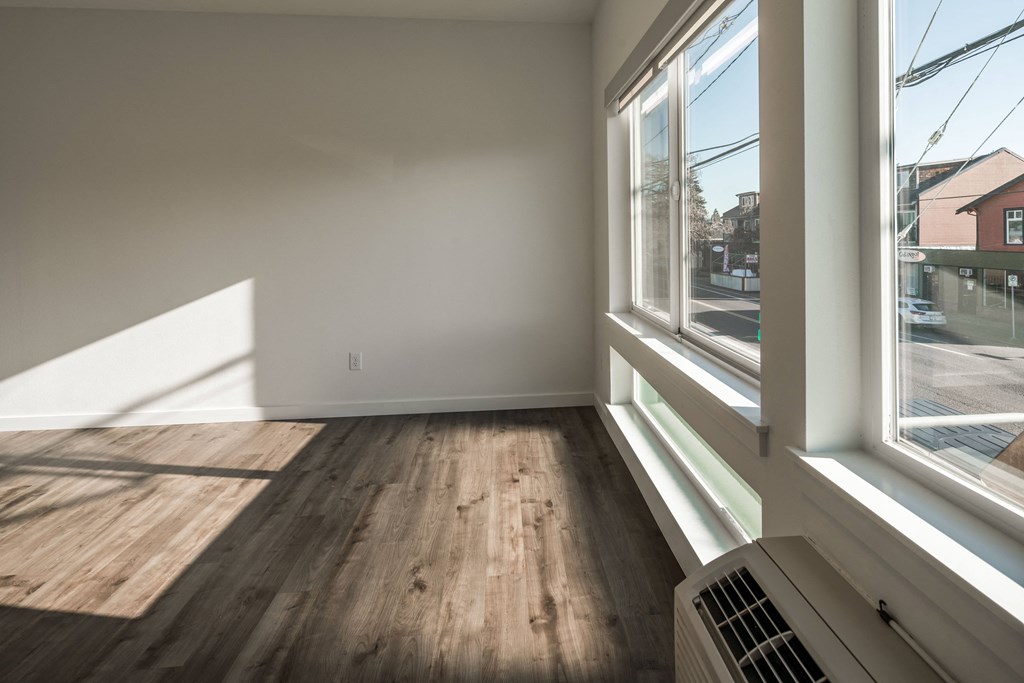 a living room with wood floors and a large window