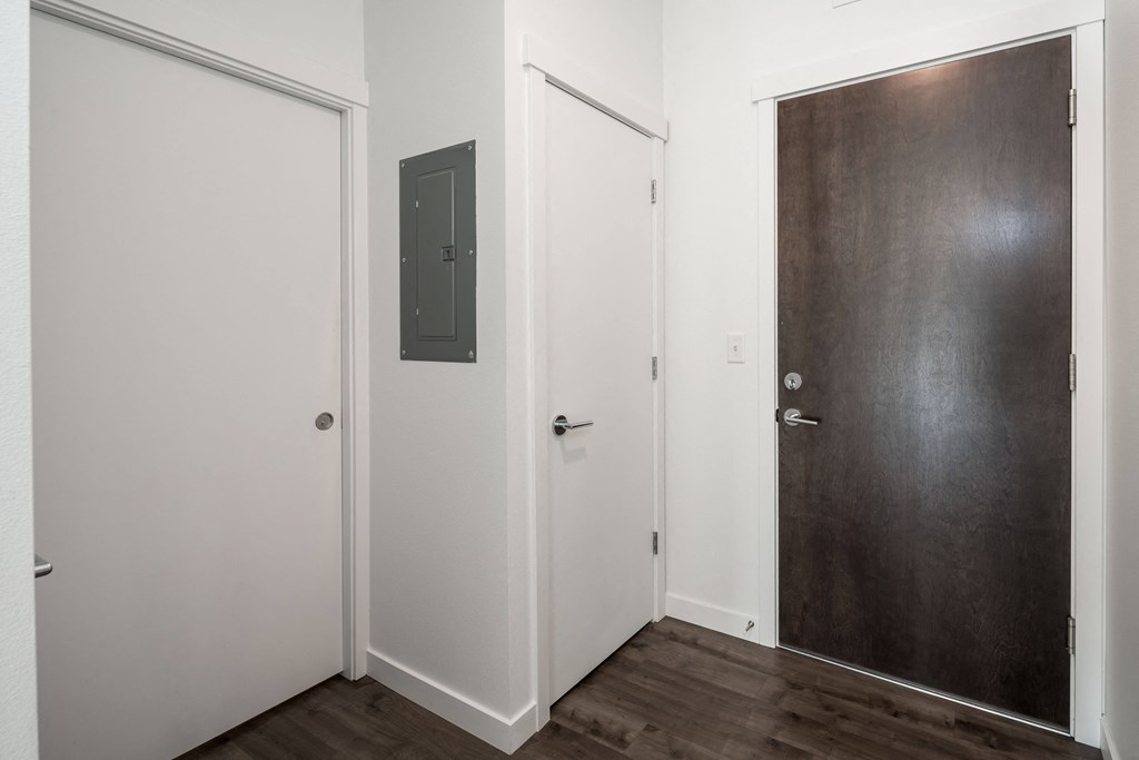 a door in a room with a wooden floor and white walls