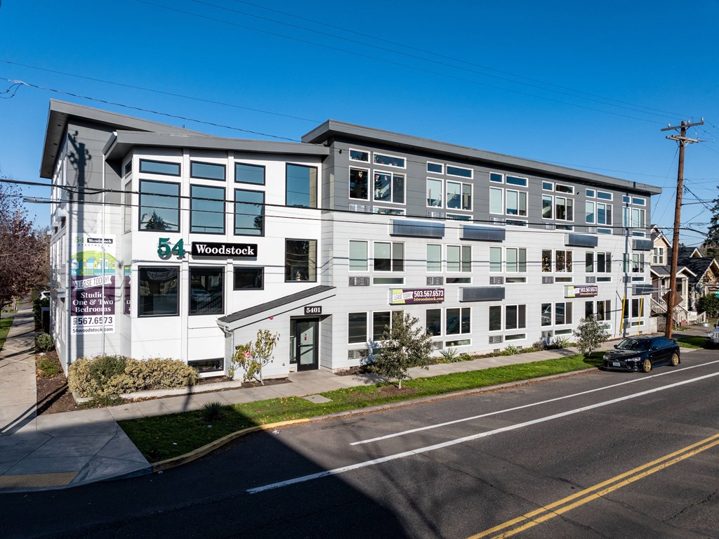 a large white building with a street in front of it