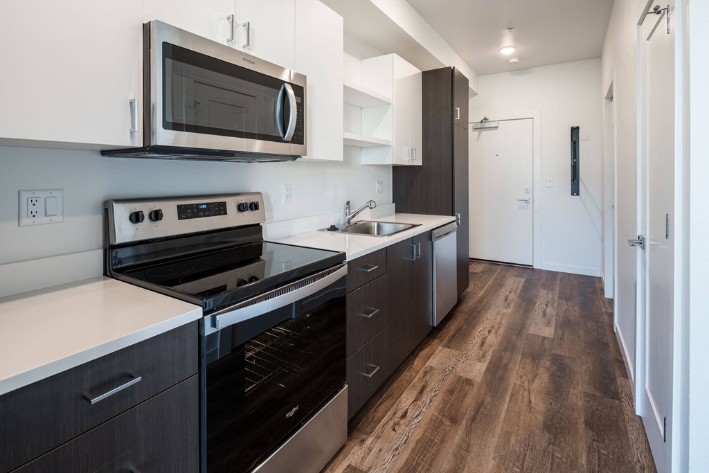 a kitchen with a stove and a microwave and a sink