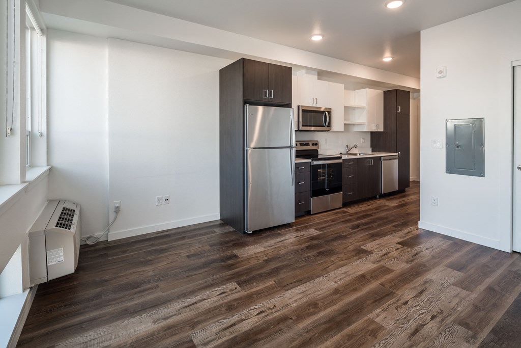 a kitchen and living room with a stainless steel refrigerator and