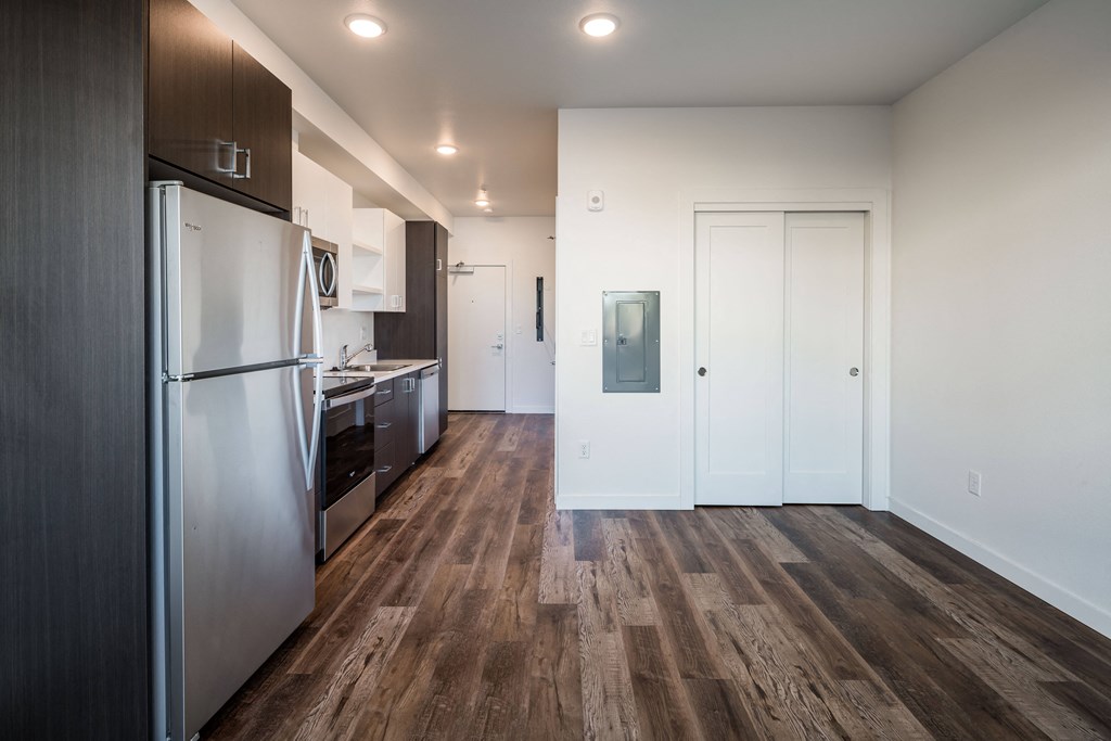 renovated kitchen with stainless steel appliances and wood flooring in an apartment