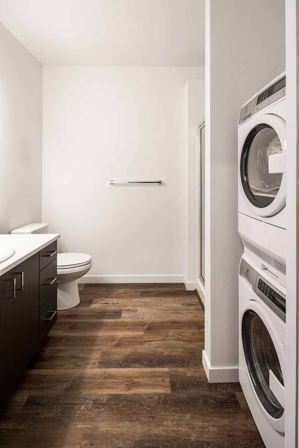 a bathroom with a washer and dryer in it and a toilet and sink