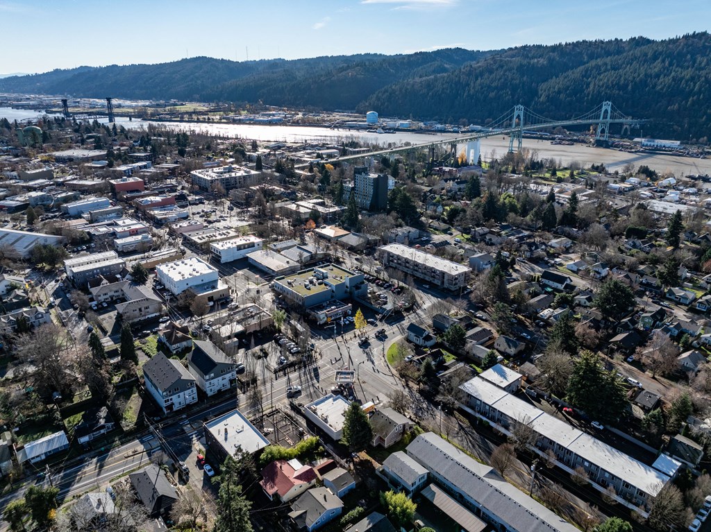 an aerial view of the city with a bridge in the background