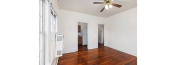 a bedroom with hardwood floors and white walls
