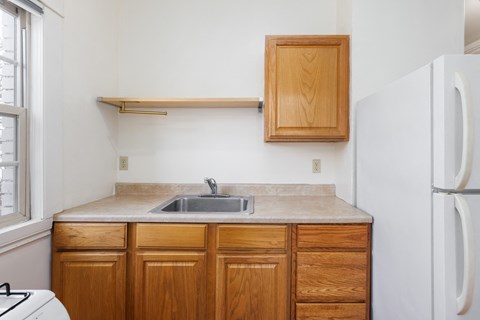 a kitchen with wooden cabinets and a sink and a refrigerator
