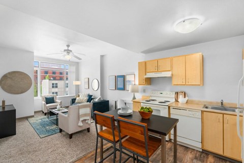 A kitchen with a table and chairs in front of it.