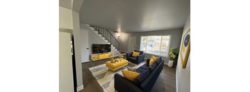 A living room with a yellow sofa and a blue couch.