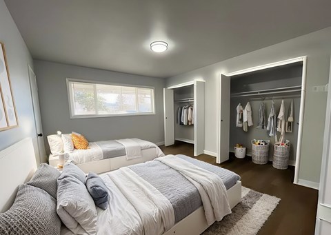 A bedroom with two beds and a walk-in closet.