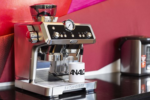 a espresso machine on a counter with a cup of coffee at Analog PDX Apartments, Portland