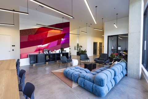 a large lobby with a blue couch and chairs at Analog PDX Apartments, Oregon