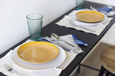 a dining table set with plates and bowls and a glass at Analog PDX, Oregon