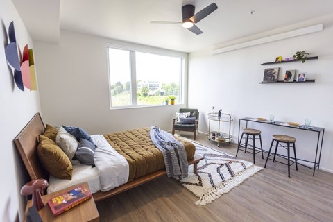a bedroom with a bed and a desk and a window at Analog PDX Apartments, Portland, OR
