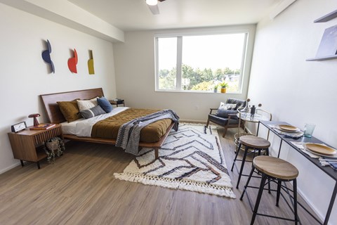 a bedroom with a bed and a desk and a window at Analog PDX Apartments, Oregon