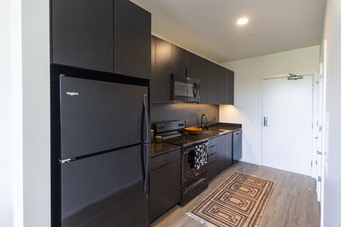 a kitchen with black appliances and a black refrigerator at Analog PDX Apartments, Portland